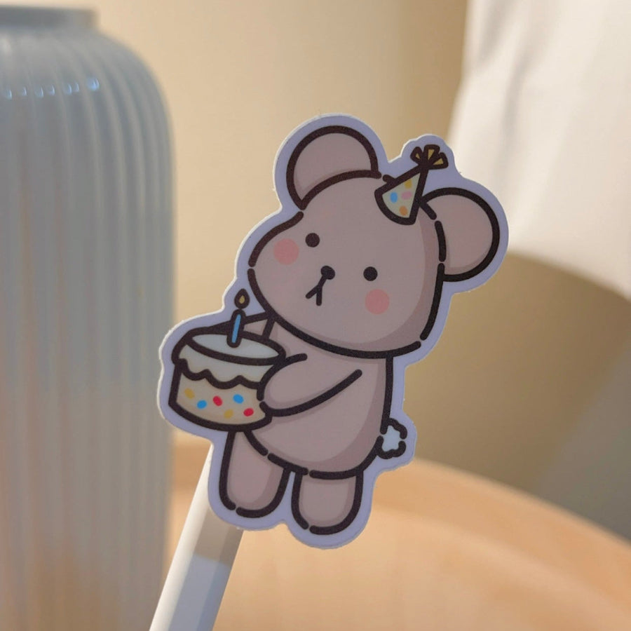 Wonki Studios' Birthday Taro sticker design shows Taro the Bear holding a cake to celebrate a birthday.